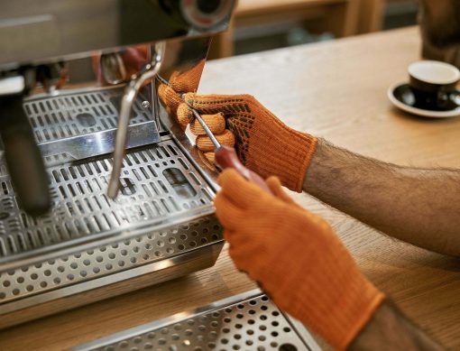 Male hands repairing coffee machine with screwdriver
